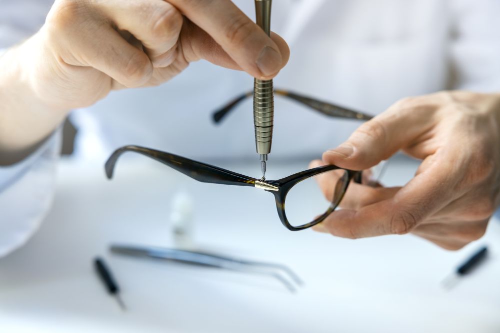 A close-up of hands adjusting or repairing a pair of glasses frames