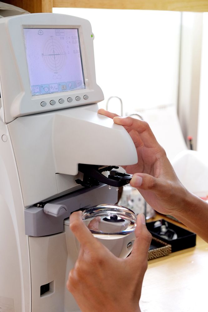 A young woman positioned in front of a slit lamp during a comprehensive eye examination