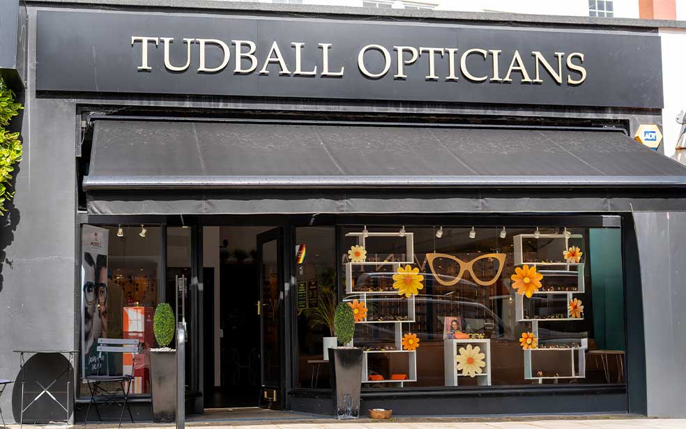 Exterior of the Tudball Opticians shopfront on Hill Road, Clevedon, with the practice name displayed prominently above the window